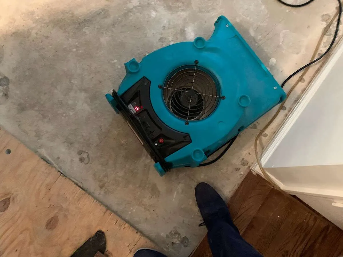 Air mover drying subfloor during Commercial Water Damage Restoration in Lincoln